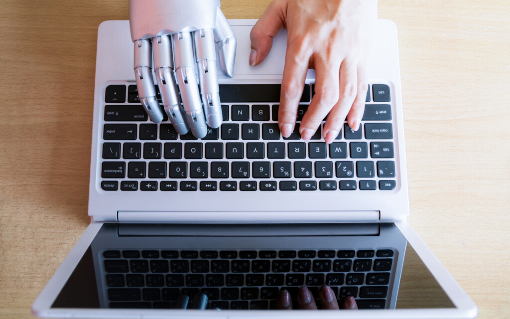 Robot hands and fingers point to laptop button advisor chatbot robotic artificial intelligence concept