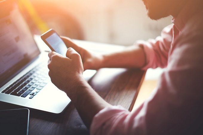 Man on smartphone and laptop